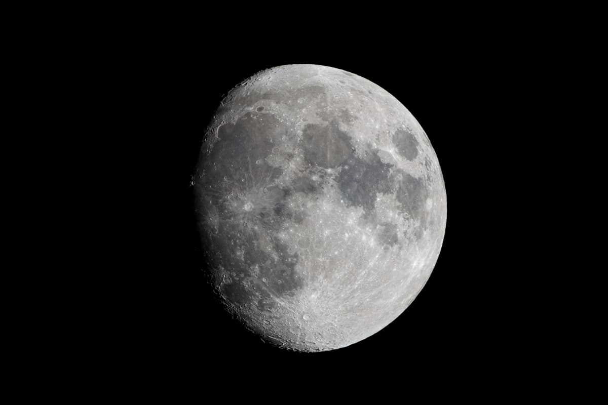 a nearly full moon against a black night sky