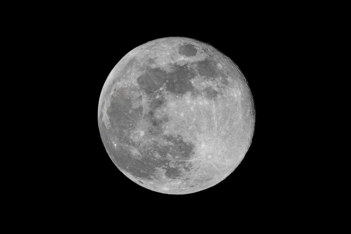 a nearly full moon against a black night sky