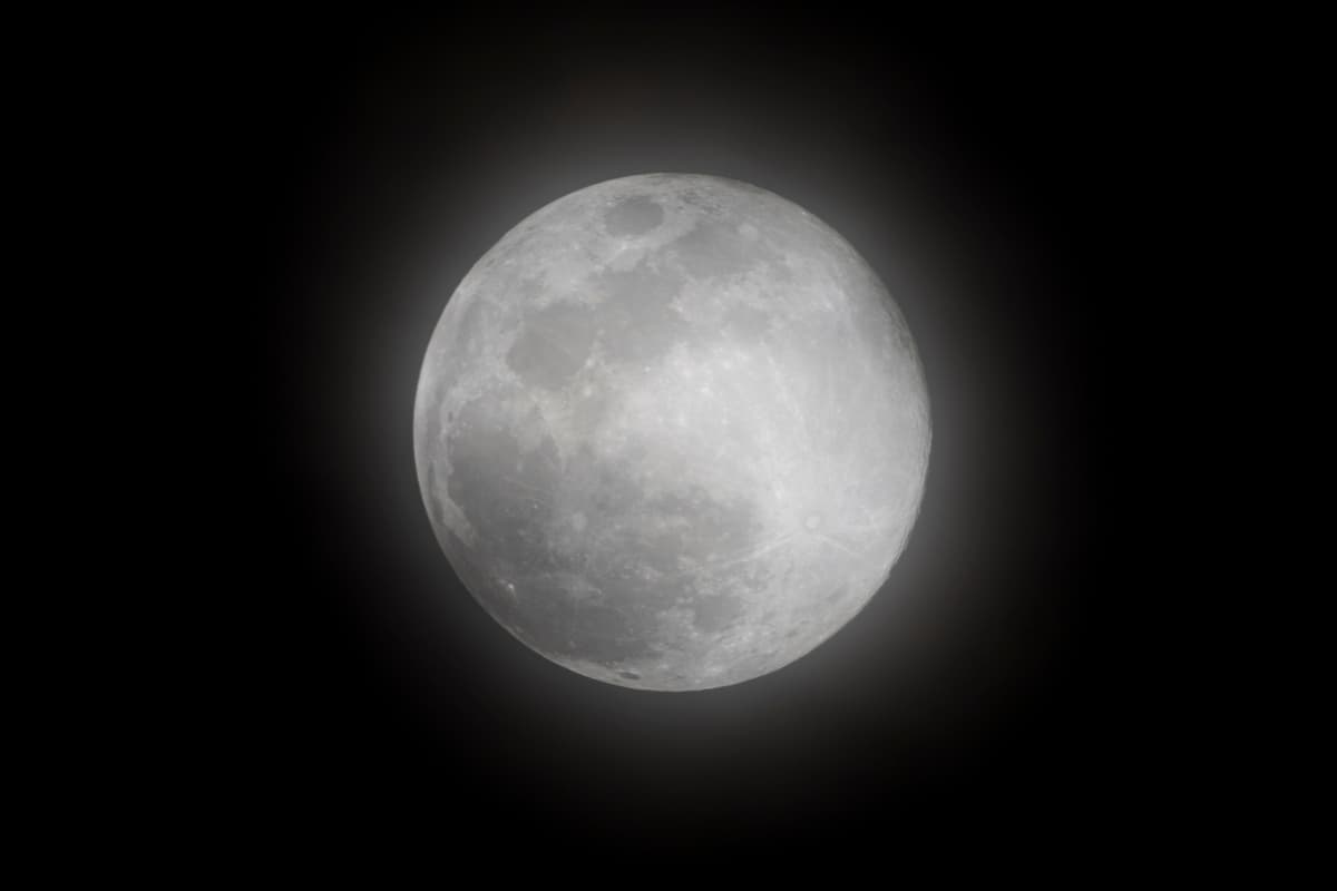 a full moon with a soft hazy glow against a black night sky