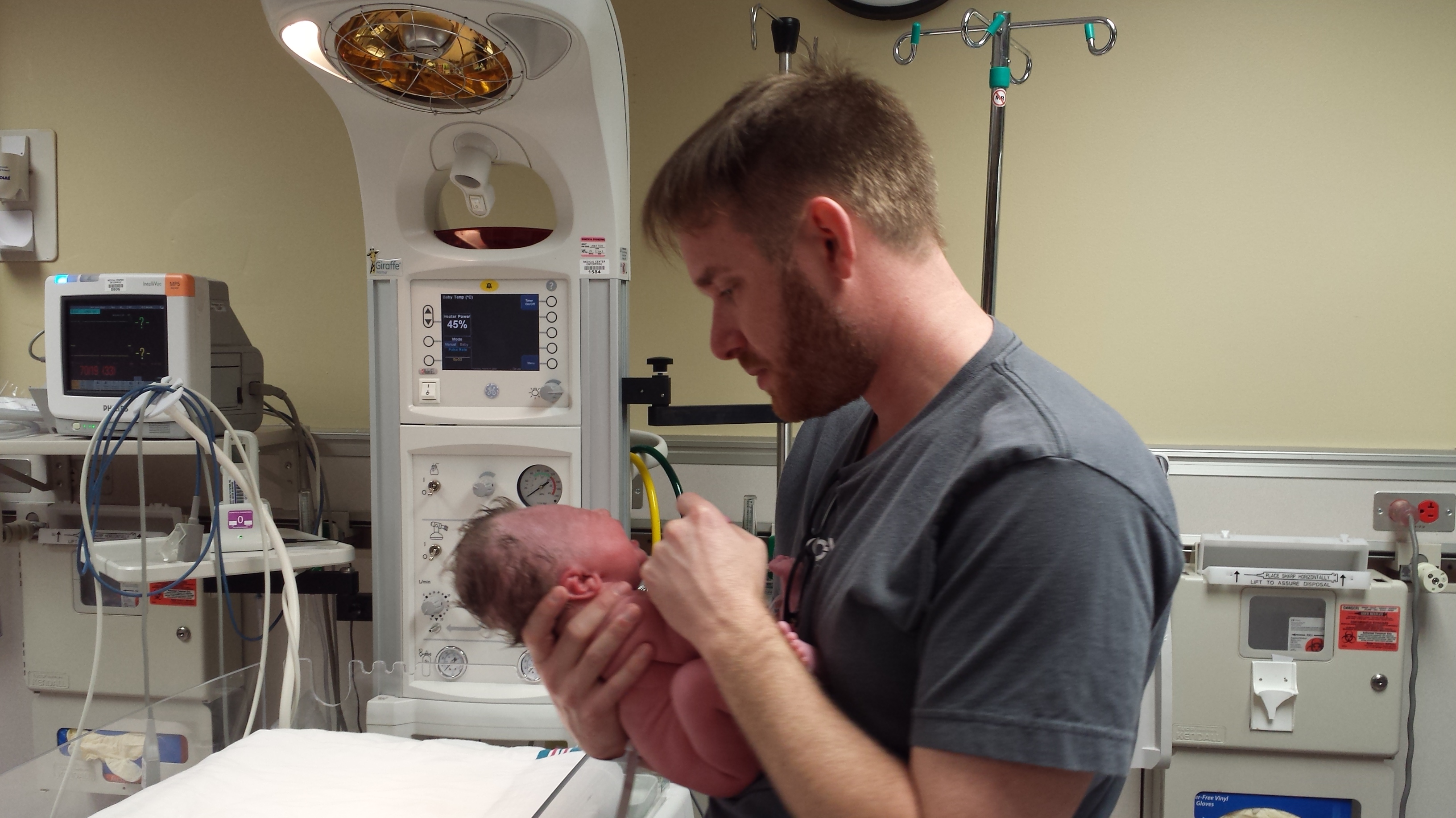 Gregory putting on Chloe's first diaper and shirt in the nursery