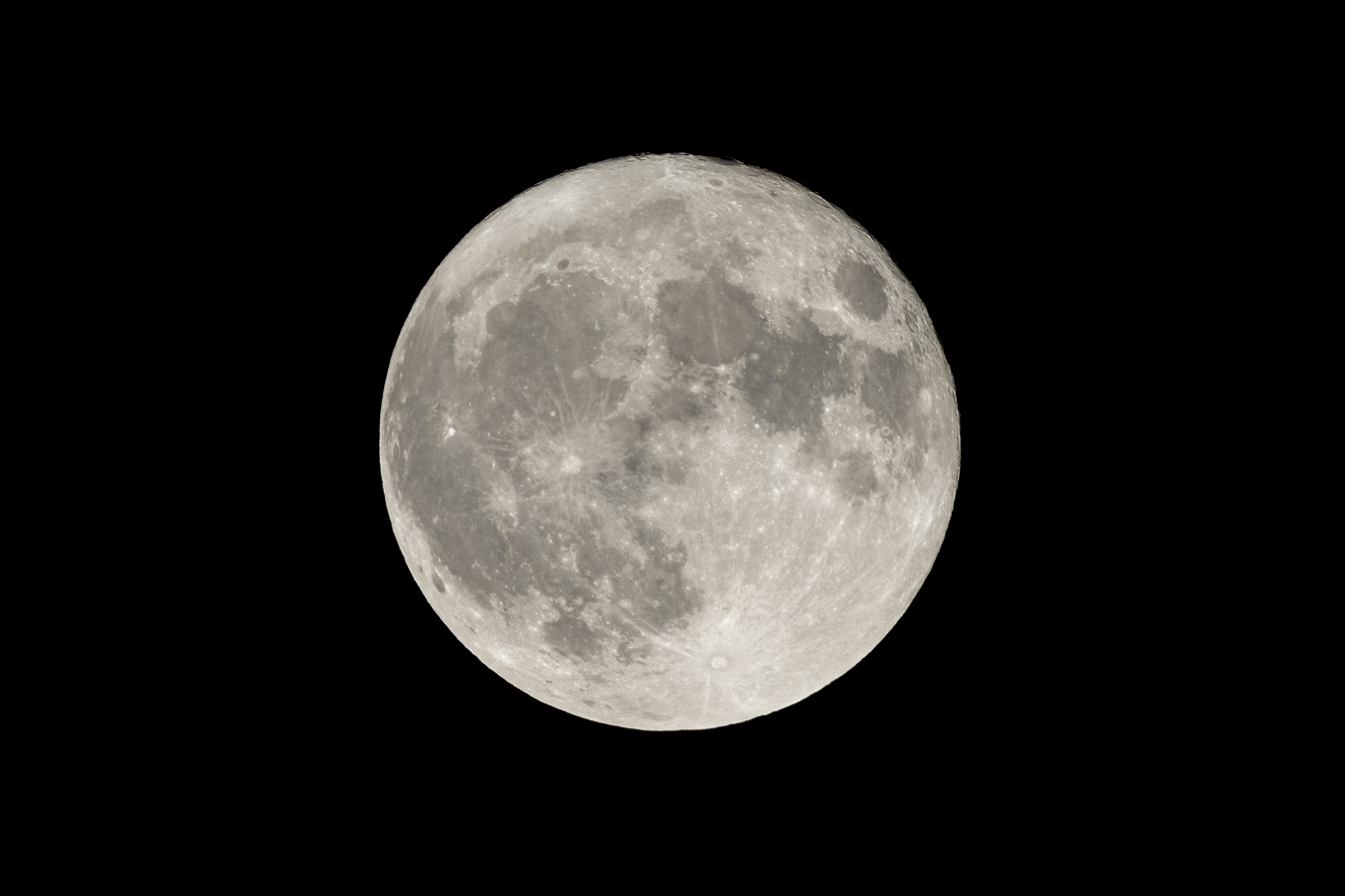 a full moon is seen in the sky with a black sky in the back ground and a plane in the foreground