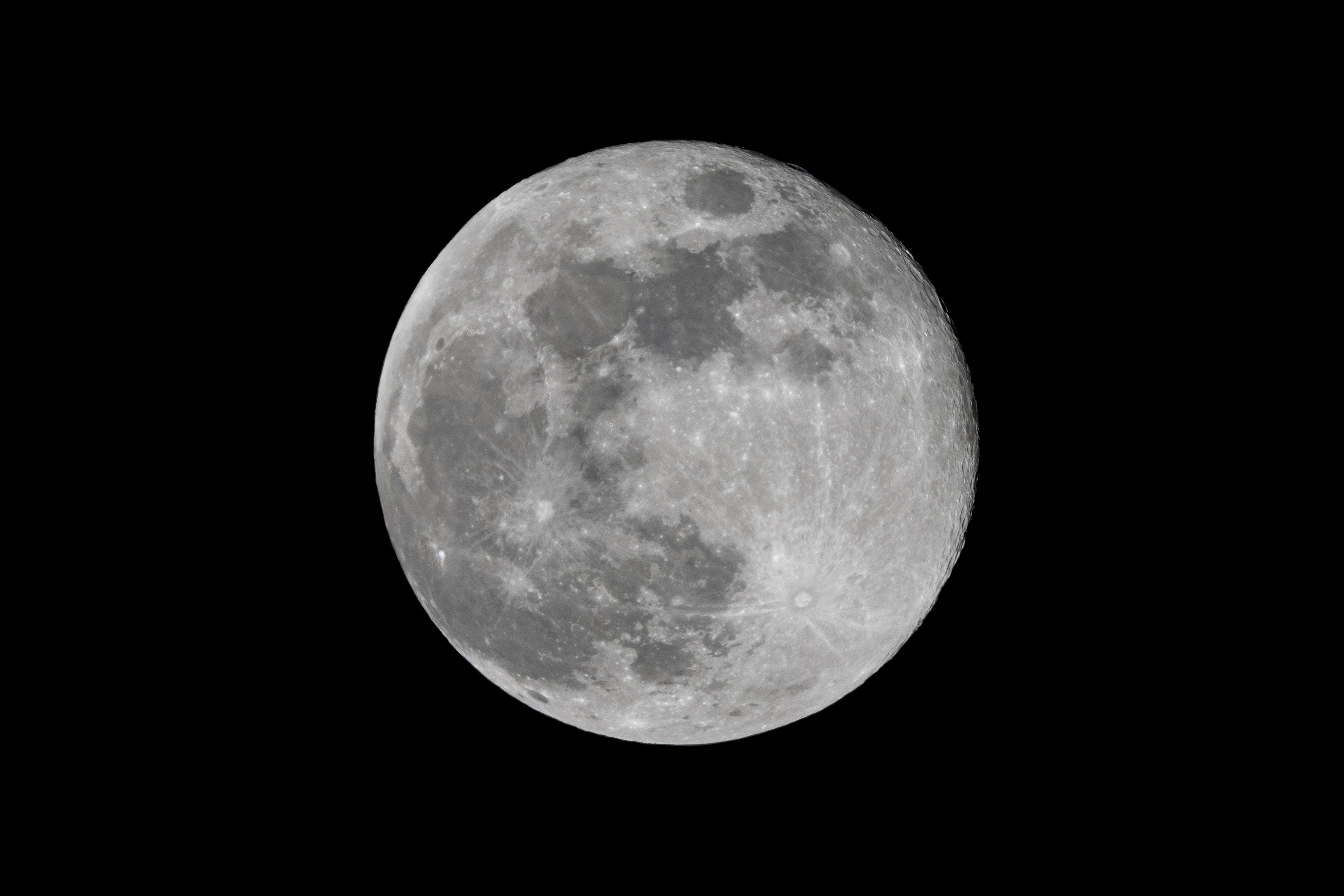 a full moon in the dark sky with a plane flying in front of it and a black sky background